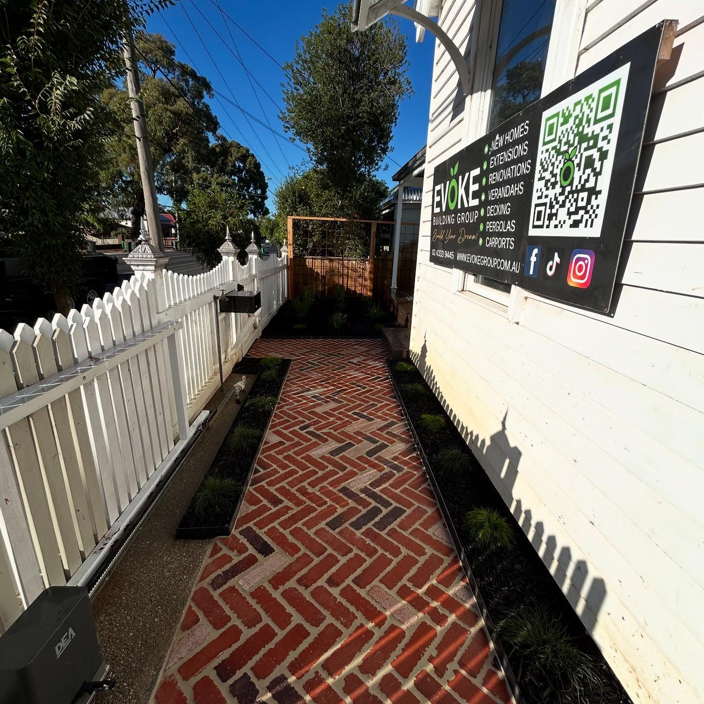 Low-maintenance front yard with red brick path